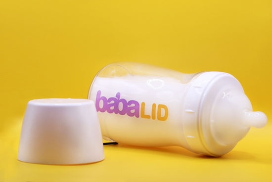 Mother feeding baby with BabaLID tethered bottle designed to prevent lost